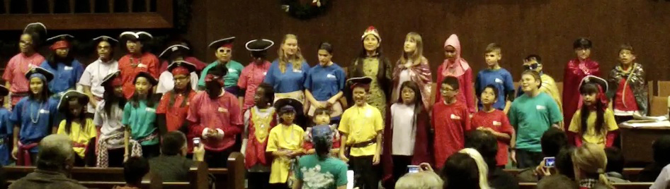 Assembly of special needs children singing on stage in costume